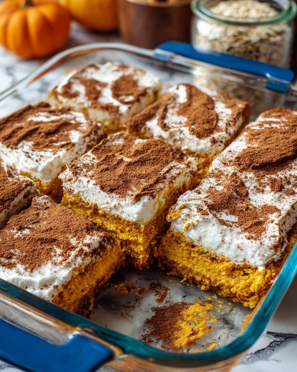 Six thick square pieces of pumpkin dessert sit in a clear glass baking dish with bright blue handles. Each piece has a bottom layer of soft, moist orange pumpkin cake, topped with a smooth, white creamy layer that is unevenly spread, showing some pumpkin cake under it. The top is sprinkled with a generous dusting of fine brown cinnamon powder, giving a textured look. One square piece is missing, revealing the soft pumpkin layer underneath. The dish is placed on a white marbled surface with blurred background items including a jar of oats and a small orange pumpkin. Photo taken with an iphone --ar 4:5 --v 7