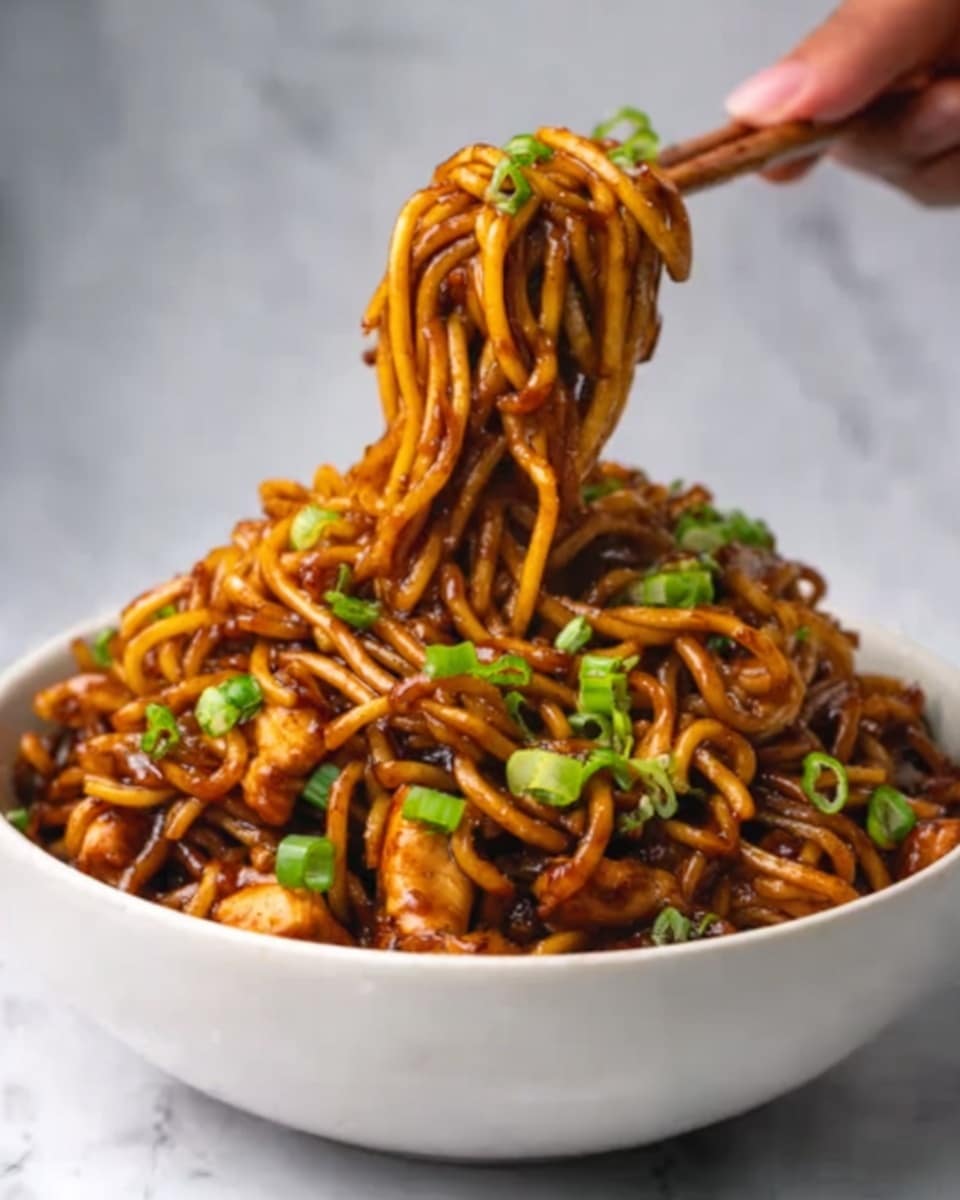 The image shows a white bowl filled with thick, dark brown noodles coated in a glossy sauce, mixed with small pieces of vegetables and meat. The noodles are lifted from the bowl by a woman's hand, creating a small nest of tangled noodles above the bowl. Green onion slices are sprinkled on top, adding a fresh green color contrast to the rich brown noodles. The background surface is a white marbled texture. Photo taken with an iphone --ar 4:5 --v 7