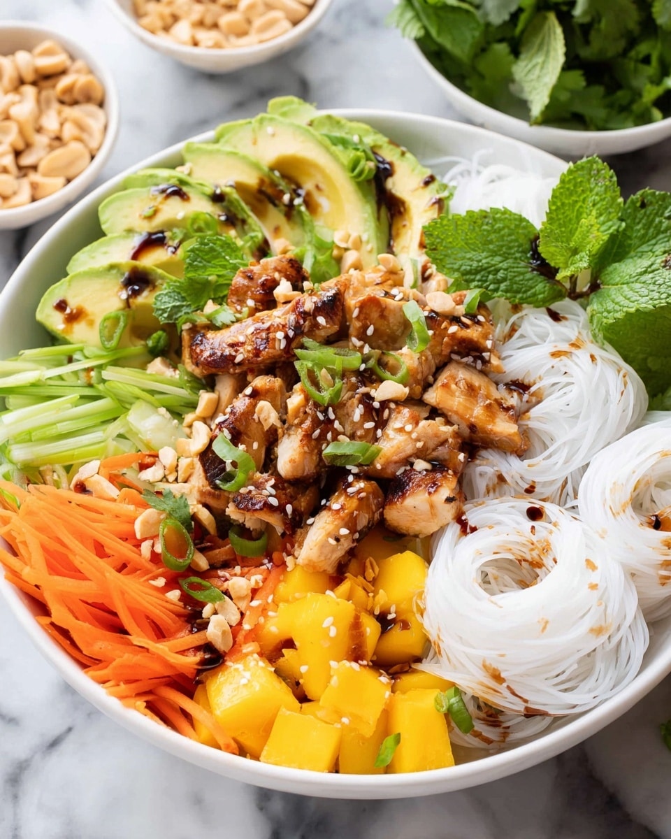 A white bowl filled with several colorful layers arranged around the edges and center. At the base are three small nests of plain white rice noodles placed on the right and bottom center. Grilled chicken pieces, brown with caramelized edges, sit in the middle, drizzled with tan peanut sauce and sprinkled with chopped peanuts and black sesame seeds. Around the edges are bright orange carrot sticks on the top left and bottom right, bright yellow mango cubes on the left and bottom right, thin diagonal green onion slices on the right, and bright green avocado slices fanned out on the left side, drizzled with dark soy sauce and black pepper. Fresh cilantro leaves crown the top near the carrots, while small bright green mint leaves sit near the mango and green onions. The whole bowl rests on a white marbled surface. photo taken with an iphone --ar 4:5 --v 7