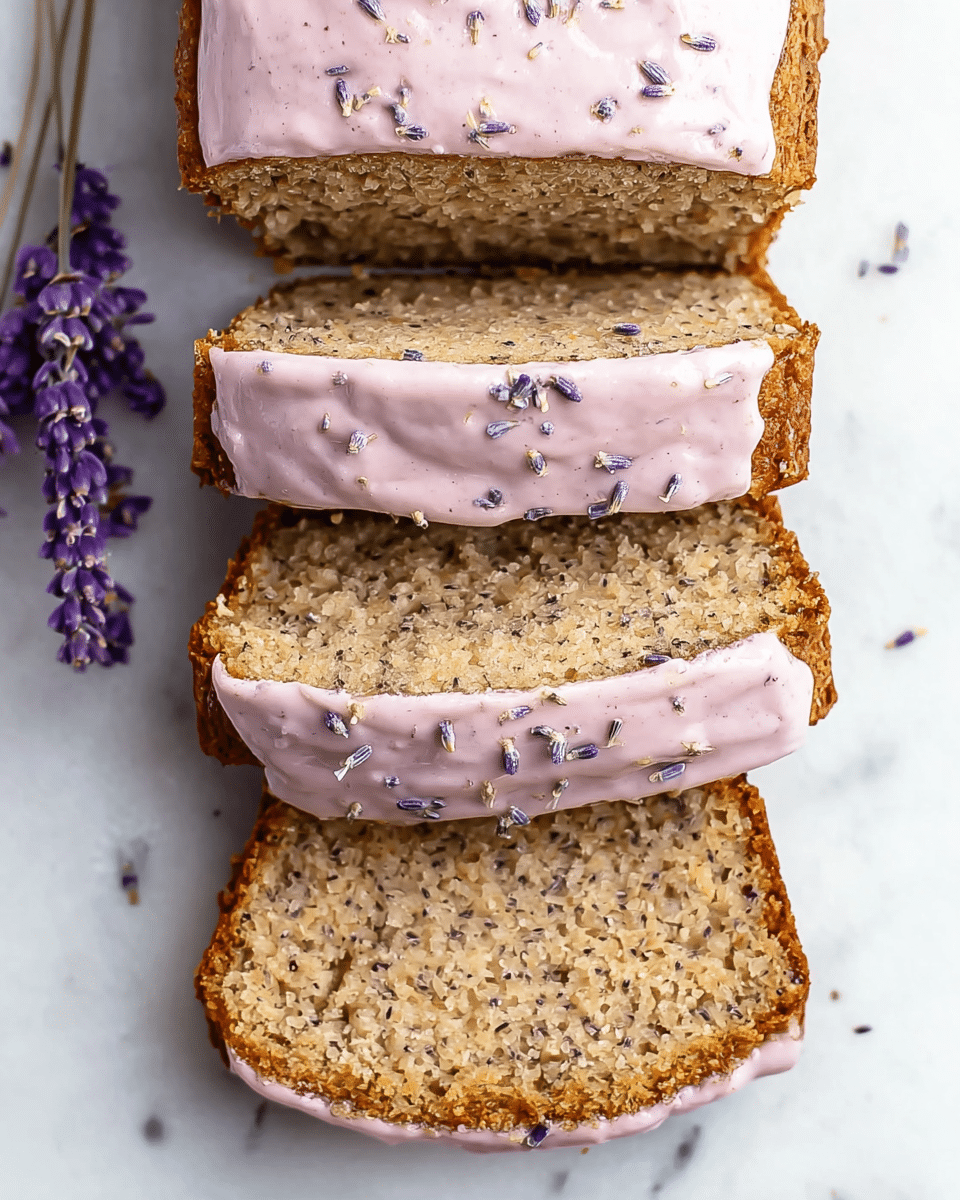 The image shows a loaf cake sliced into four layers arranged stacked vertically, each slice revealing a coarse, light brown texture with small dark specks throughout. The top layer and the spaces between the slices are coated with a smooth, pale pink frosting that has small dark lavender bits sprinkled on top, giving it a delicate, speckled look. The cake edges are golden brown, slightly rough, and contrast with the soft frosting. The cake is placed on a white marbled surface, with a small bunch of purple lavender flowers placed to the left side. photo taken with an iphone --ar 4:5 --v 7