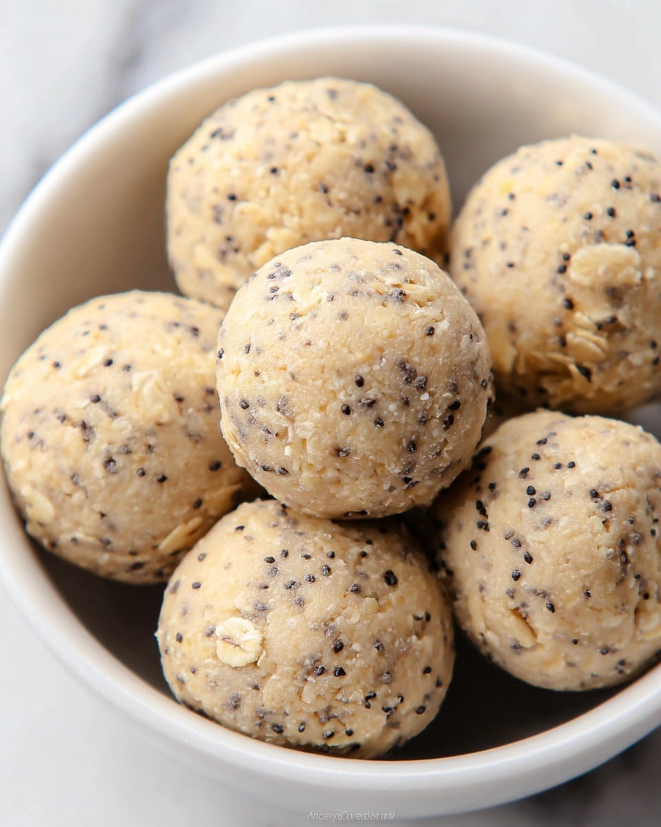 A close-up view of a white bowl filled to the top with small round pretzels covered evenly in a green herb seasoning mixed with white sesame seeds, giving the pretzels a speckled green and white texture on their shiny brown surface. The pretzels are twisted in their classic knotted shape, overlapping each other to form a dense pile. The background shows a blurred effect with light and soft shapes, placed on a white marbled surface. photo taken with an iphone --ar 4:5 --v 7