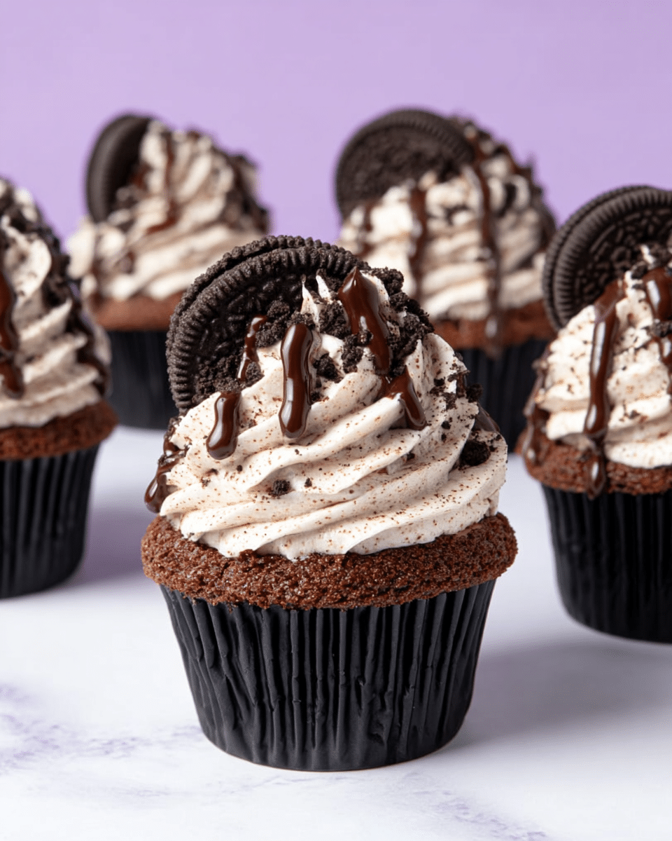 The image shows a group of chocolate cupcakes each with three main layers. The bottom layer is a dark, moist chocolate cupcake in a ridged black paper wrapper. The middle layer is a thick swirl of creamy white frosting speckled with tiny cookie crumbs, placed high on top of the cupcake. The top layer is a drizzle of rich dark chocolate sauce that runs down the frosting’s curves. Each cupcake is garnished with a whole dark chocolate sandwich cookie pressed vertically into the frosting on one side. The cupcakes are set against a smooth white marbled surface with a soft purple background. photo taken with an iphone --ar 4:5 --v 7