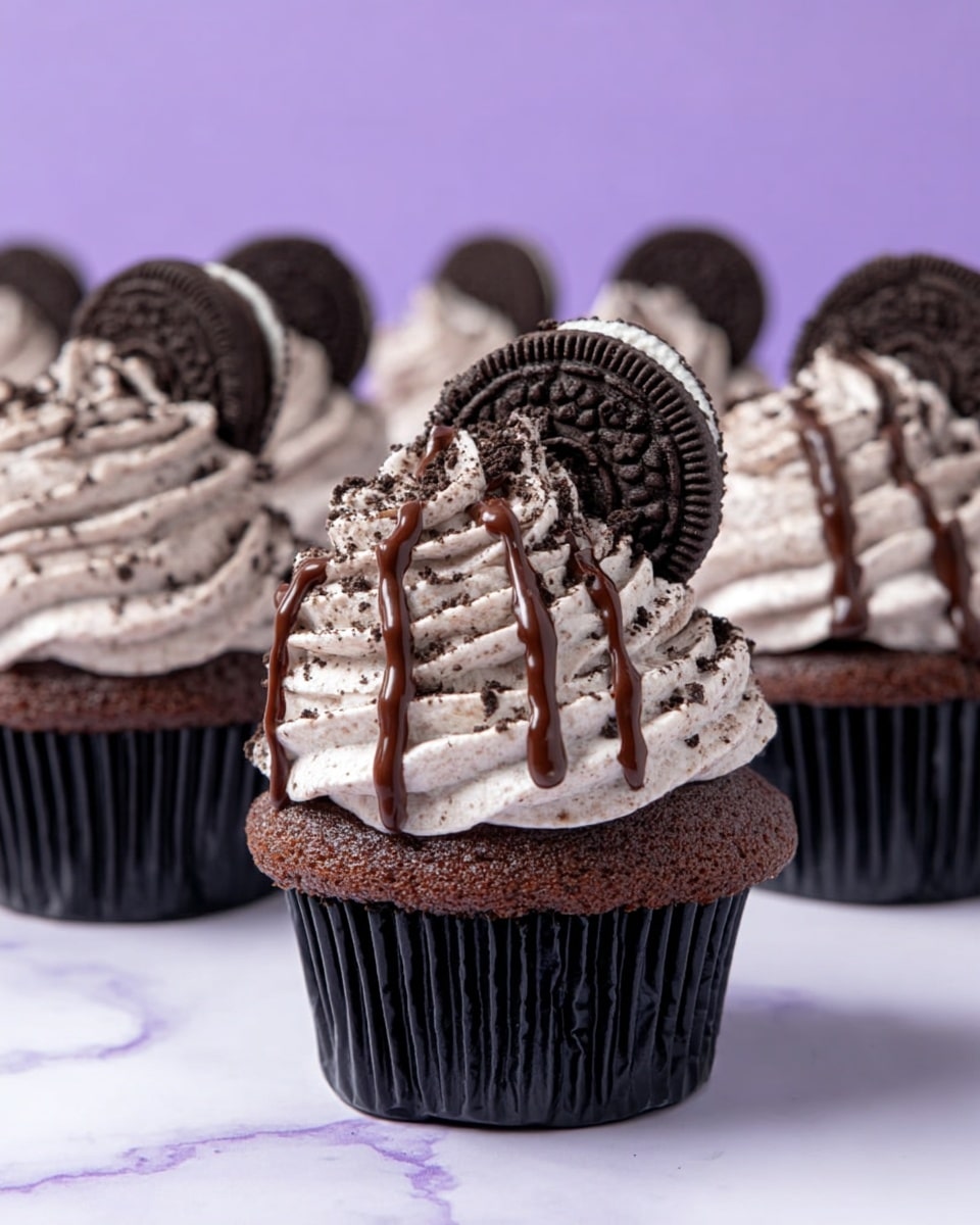 The image shows several chocolate cupcakes, each with a dark brown base that looks soft and moist. On top, there is a thick swirl of light cream frosting with small dark specks, resembling cookies and cream texture. Each cupcake has a round chocolate sandwich cookie placed on one side, slightly pushed into the frosting. The frosting is drizzled with thin lines of shiny dark chocolate sauce. The cupcakes are arranged on a white marbled surface with a soft purple background. photo taken with an iphone --ar 4:5 --v 7